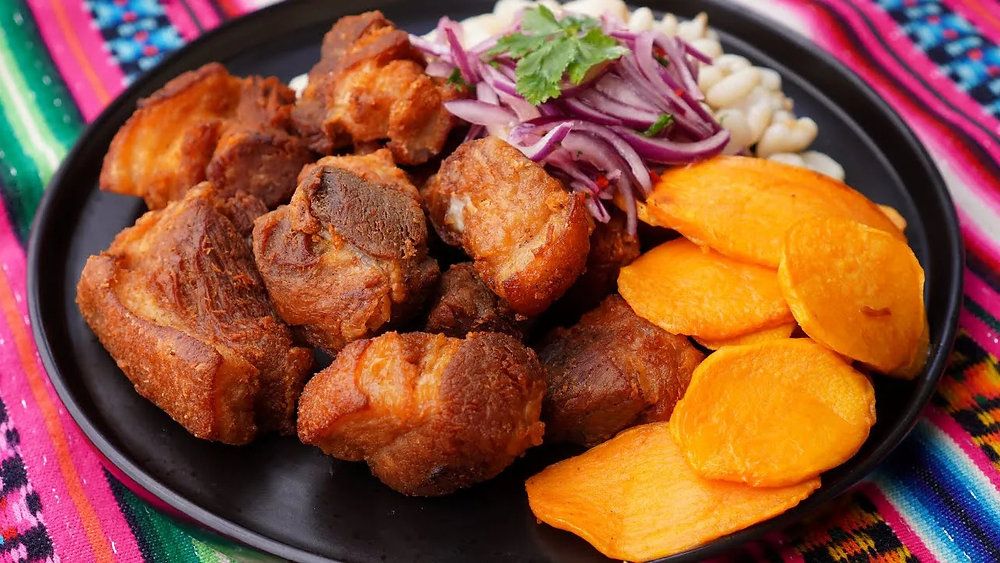 Peruvian-style chicharrón, crispy fried pork belly served with sweet potato and pickled red onions